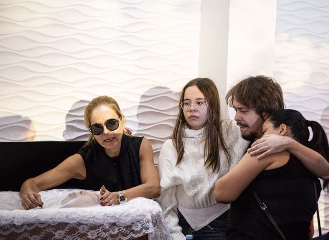 Abalados, esposa e filhos de Chrystian choram em velório do cantor