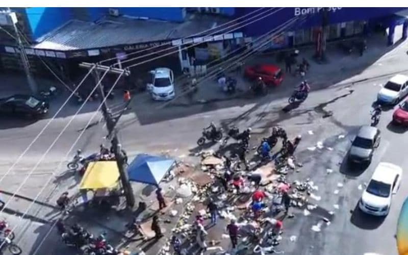 VÍDEO: Caminhão tomba durante curva e população saqueia carga no Nova Cidade