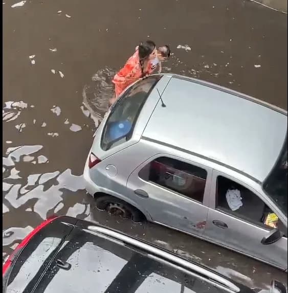 VÍDEOS: Mulher com bebê de colo tenta empurrar o carro em passagem de nível alagada na Darcy Vargas