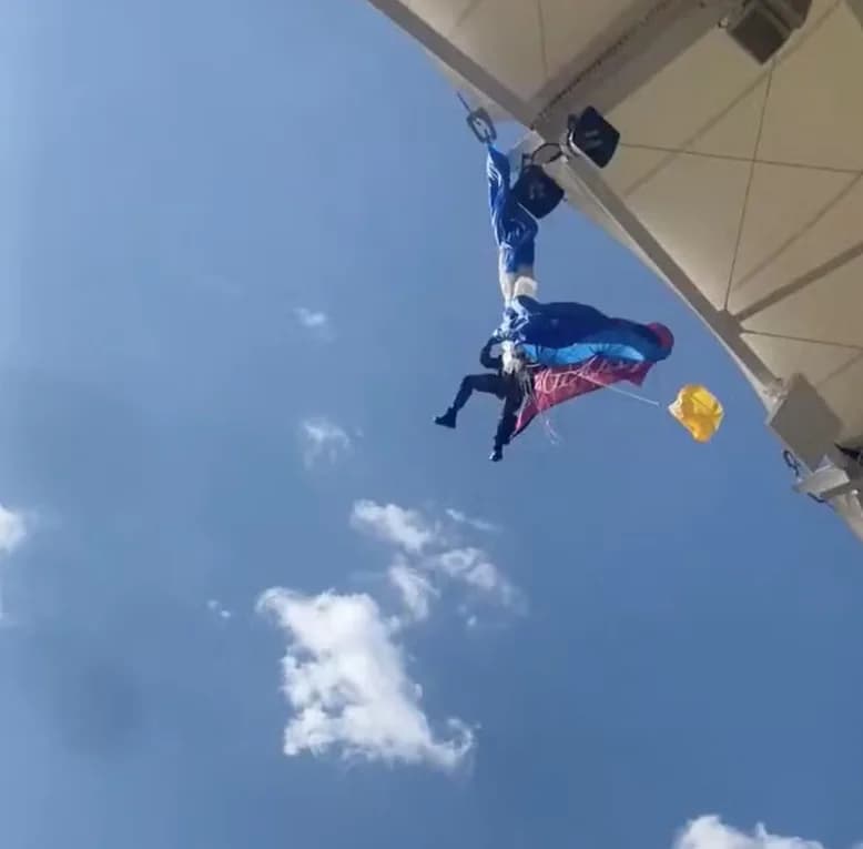 Paraquedista fica preso no teto de estádio ao levar bola de jogo na Copa dos Campeões